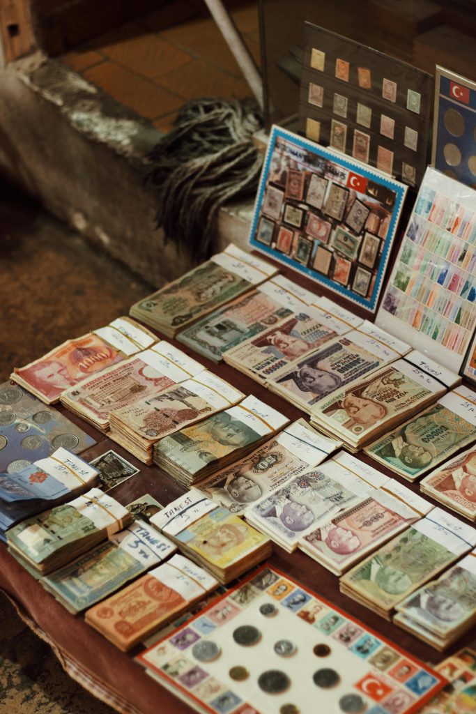 Intriguing close-up of assorted vintage banknotes and coins displayed on a market table.