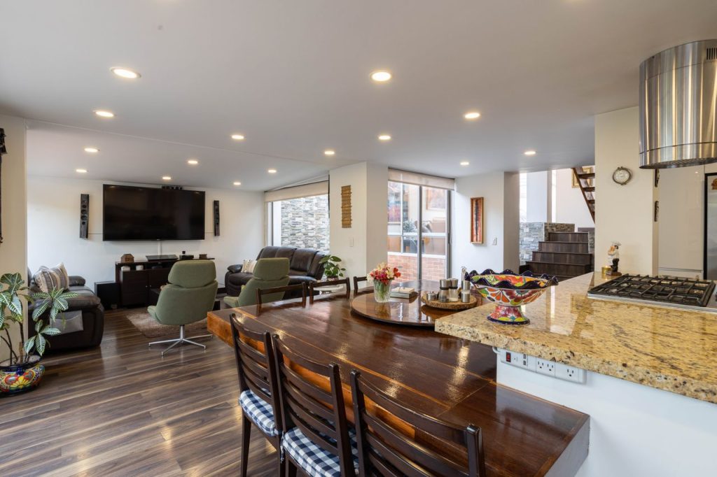 Spacious and elegant living room and dining area with modern interior design in a Bogotá home.