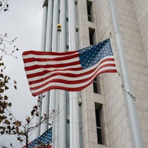 Low angle of American flag waving in front of a government building in Anaheim, CA.