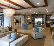 Spacious living room with elegant decor and an open kitchen area, featuring a chandelier and comfortable furnishings.